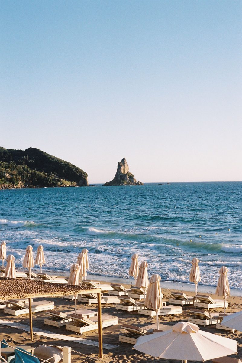 Peaceful beach scene with sunbeds and umbrellas facing the ocean during the day.
